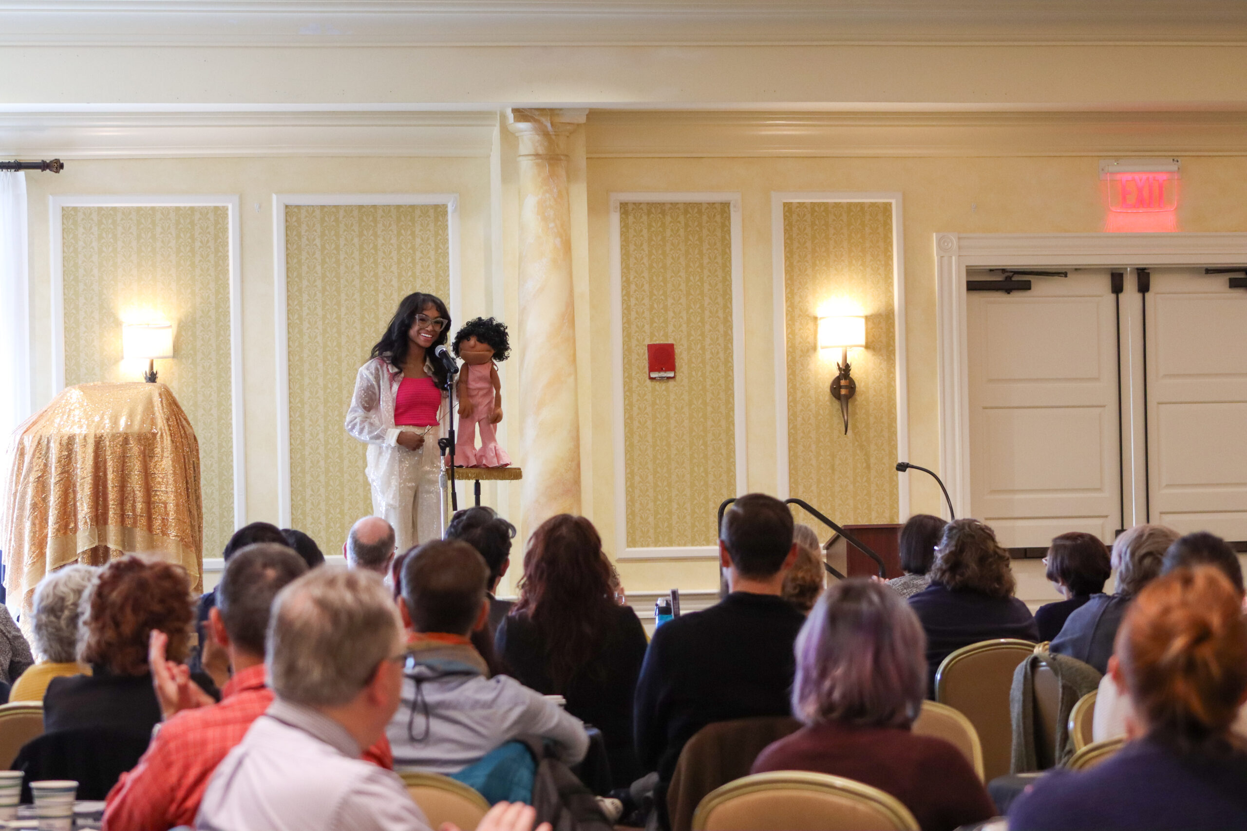 Megan Piphus and her puppet in front of a crowd.