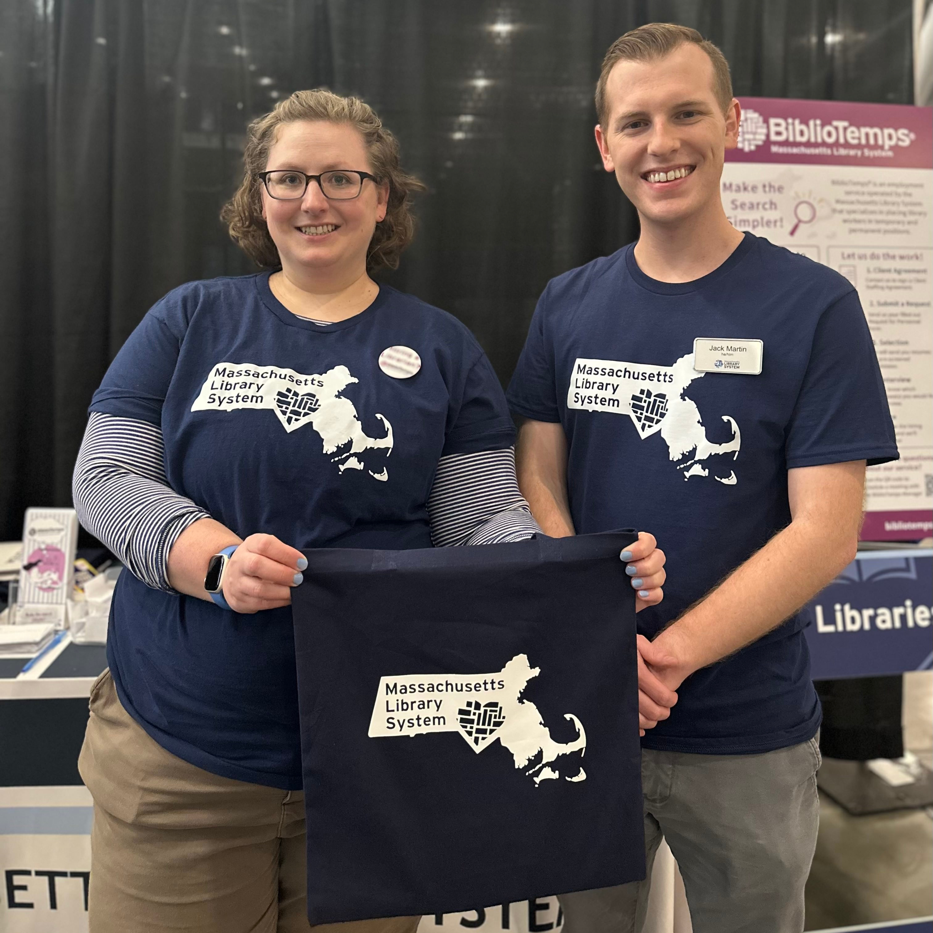 Amanda Fauver and Jack Martin wearing shirts with a heart over the shape of Massachusetts and text reading: "Massachusetts Library System."